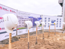 Bauhelme auf Spaten auf Sandhaufen in Vorbereitung des 1. Spatenstichs des Neubaus in der Brandprüfstelle der MFPA