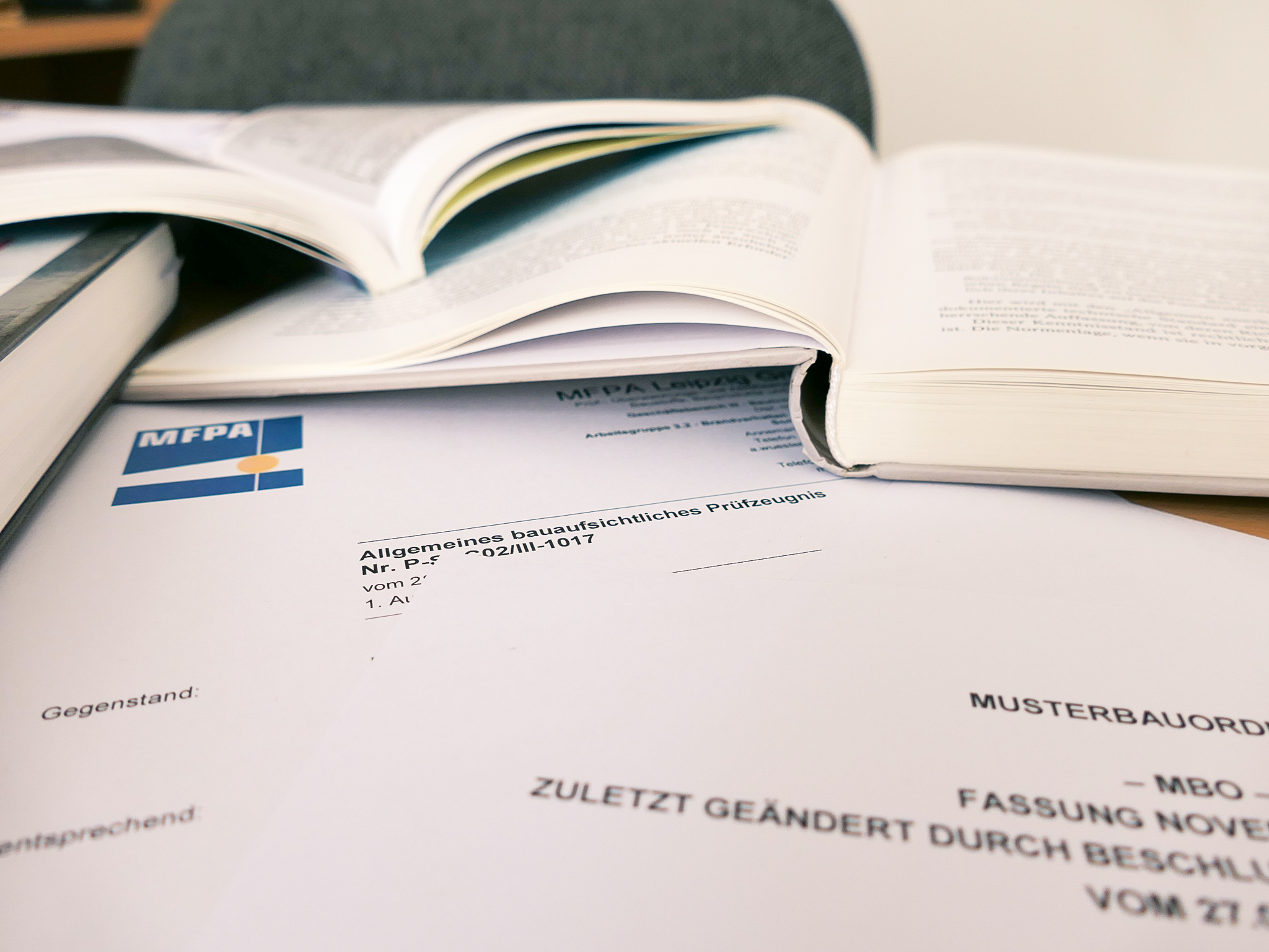 Detailaufnahme von Baudokumenten und Büchern auf einem Schreibtisch