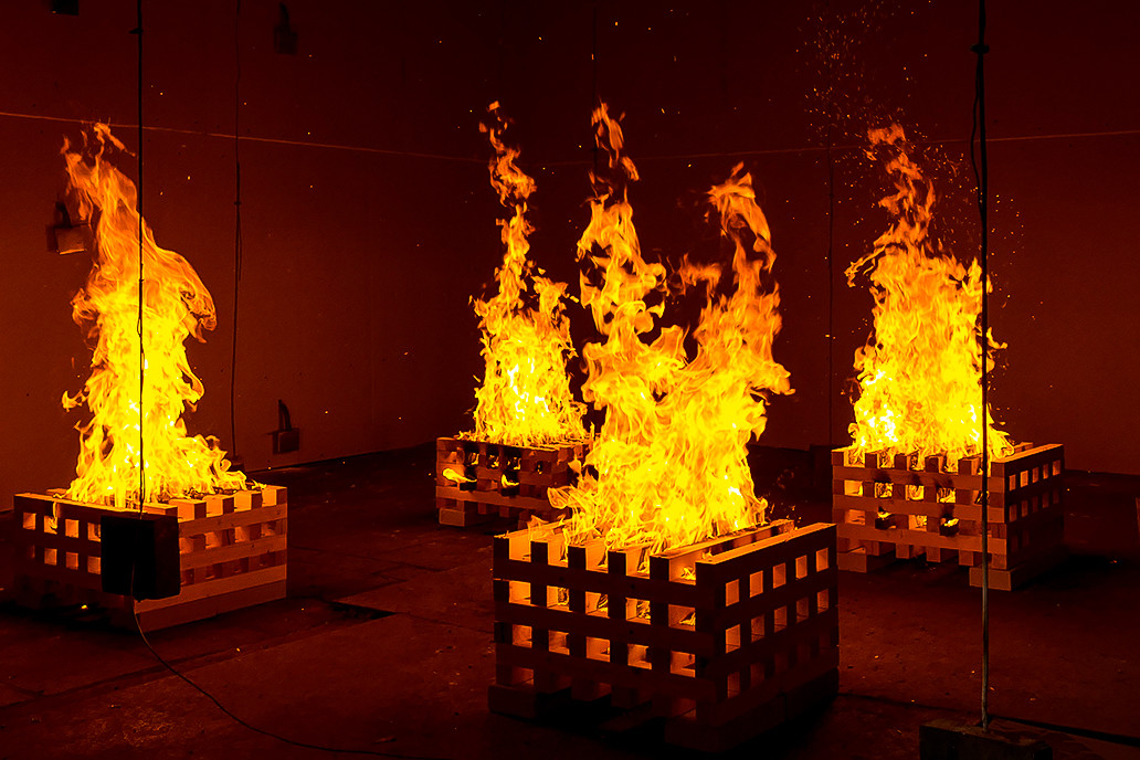 angezündete Holzkrippen aus denen Flammen schlagen während eines Brandschutztests