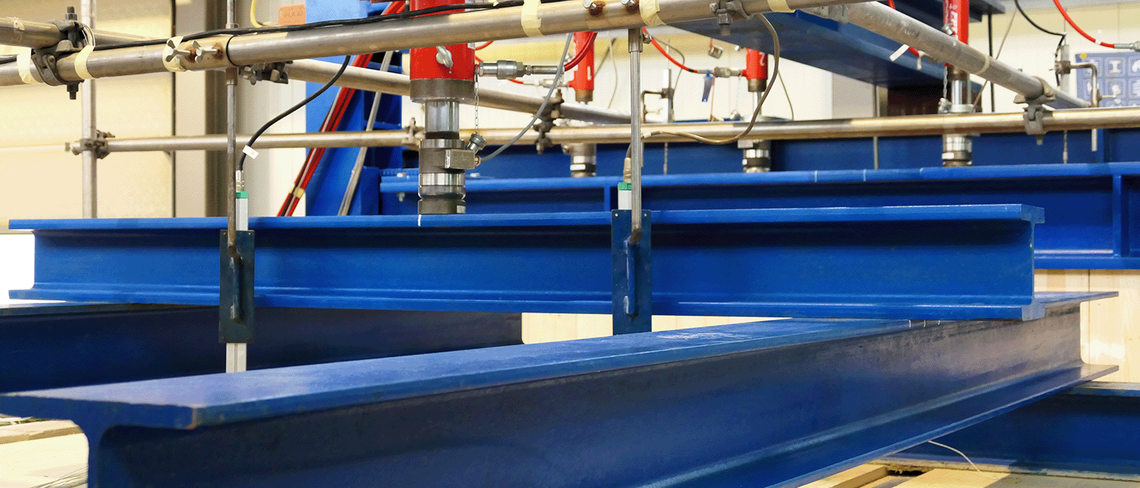 Hydraulische Vertikalbelastung mehrerer Stahlträger bei einem Brandversuch