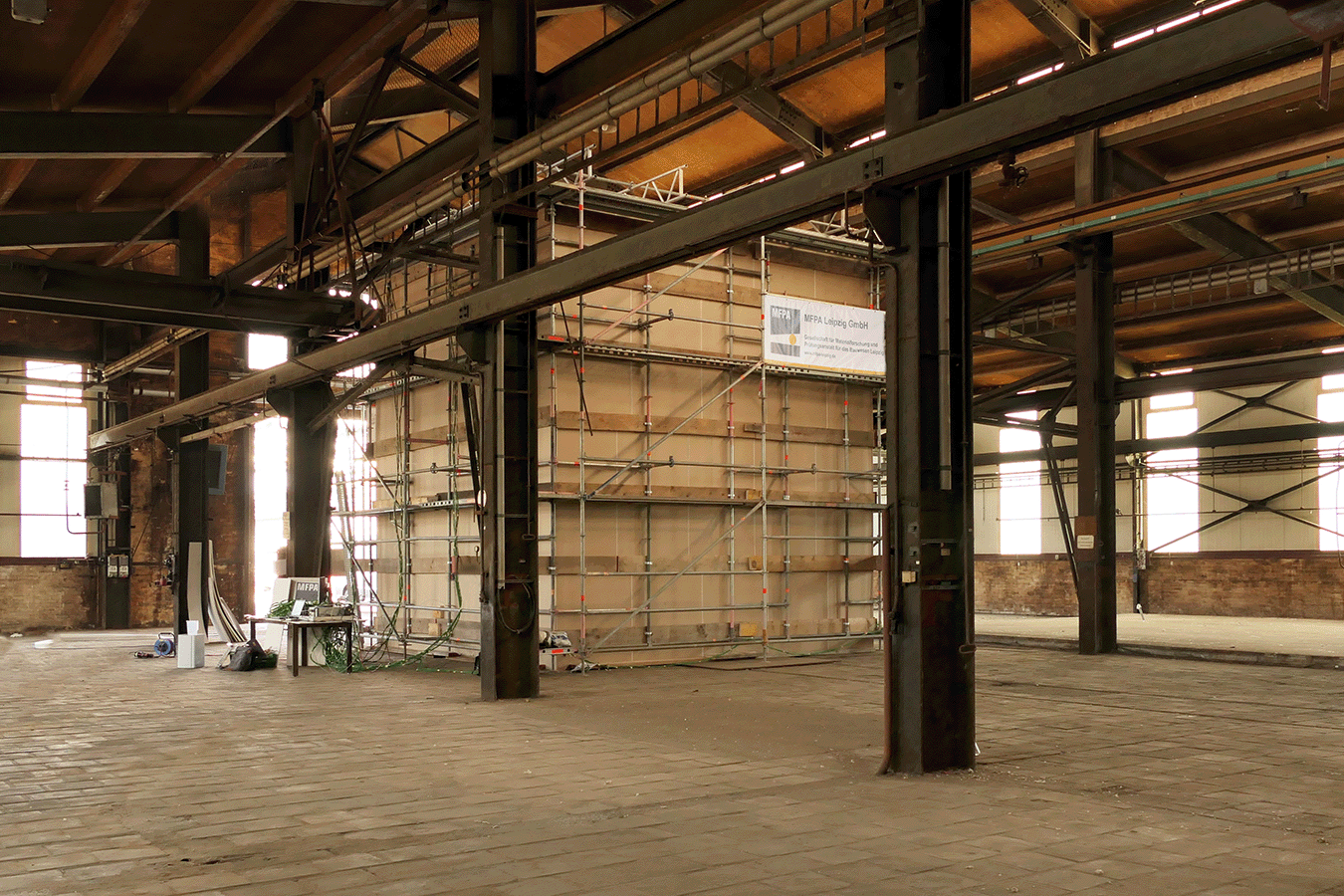 Brandversuche zur Löschwirkung einer Feuerlöschanlage mit einem maßstabsgetreuen Nachbau eines Raumes in einer alten Industriehalle