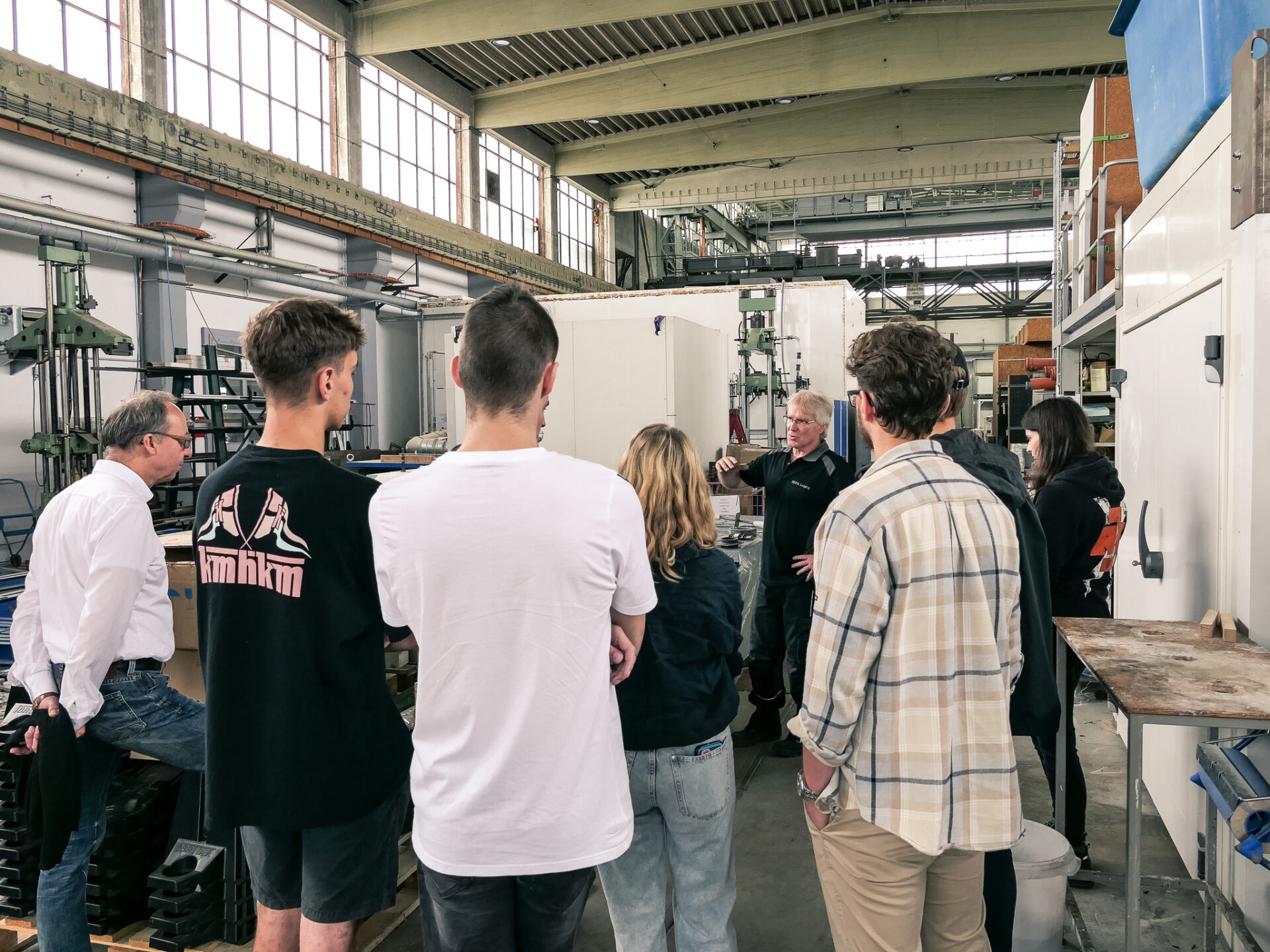 Studierende bekommen eine Erkl&auml;rung an Pr&uuml;fmaschinen w&auml;hrend einer Exkursion