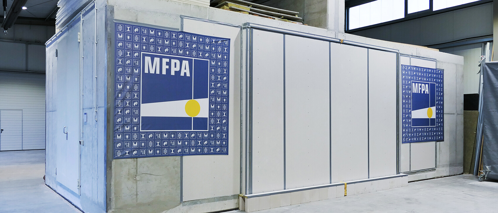 Au&szlig;enansicht eines L&auml;ngsschallleitungspr&uuml;fstands der MFPA aus Beton in einer Pr&uuml;fhalle