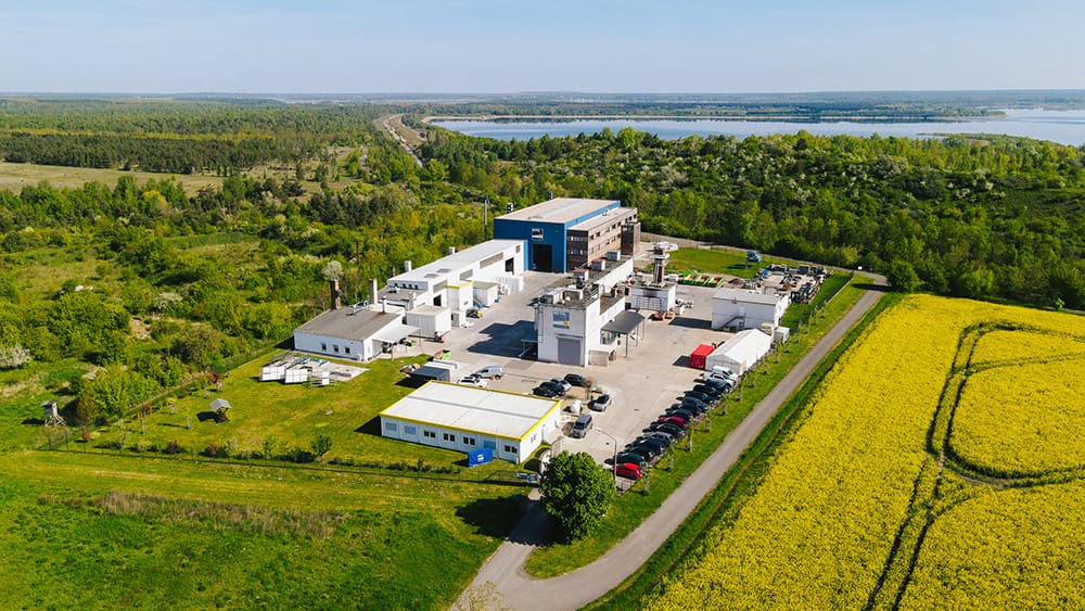 Drohnenaufnahme der Brandpr&uuml;fstelle in Laue bei Delitzsch mit einem gelben Rapsfeld und einem See im Hintergrund