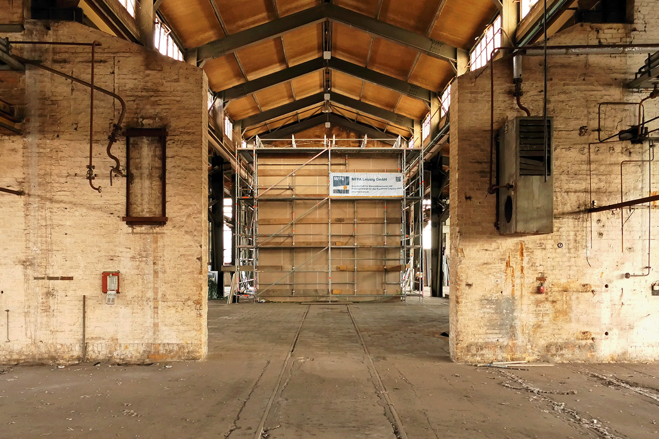 Brandversuche zur Löschwirkung einer Feuerlöschanlage mit einem maßstabsgetreuen Nachbau eines Raumes in einer alten Industriehalle